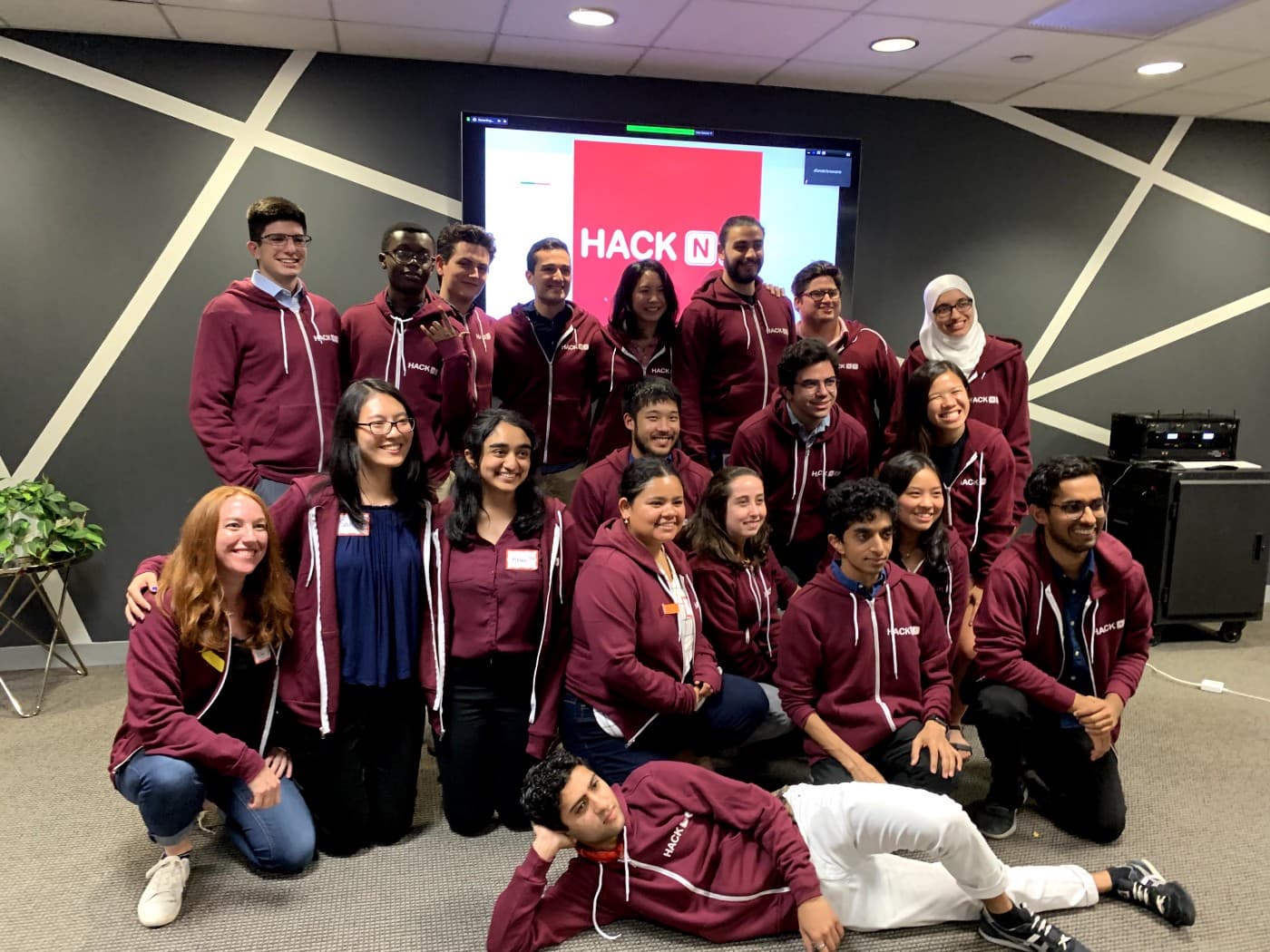 The hackNY class of 2019 smiles for a picture in their hoodies.