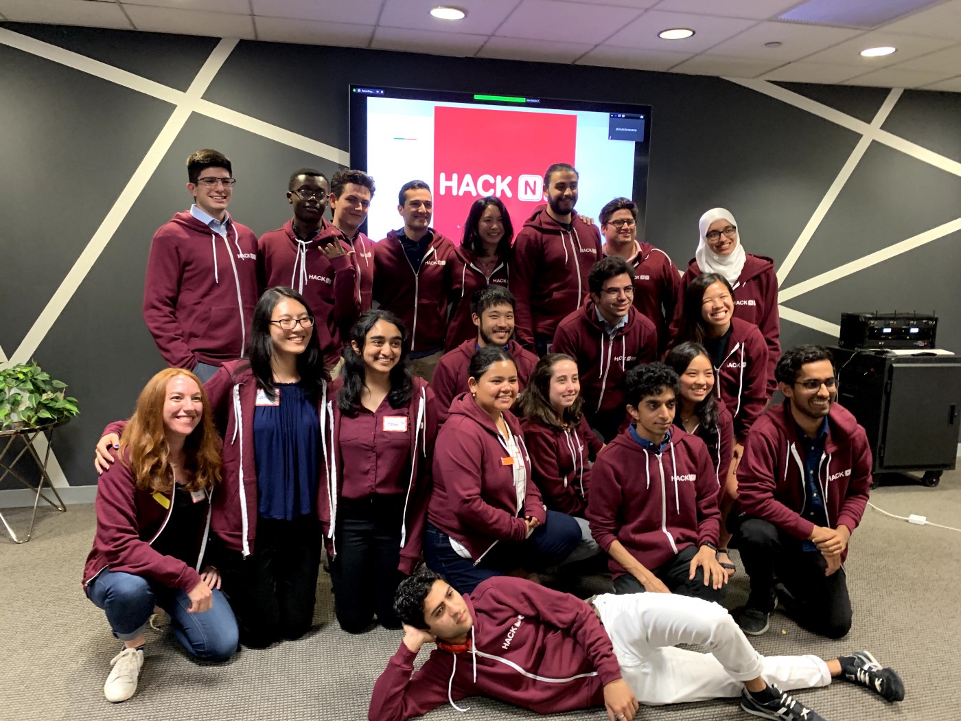 The hackNY class of 2019 smiles for a picture in their hoodies.